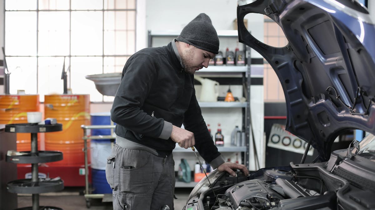 A technician performing a brake fluid flush on a vehicle